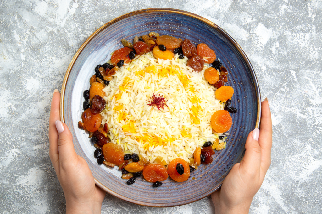 Traditional Persian saffron rice featuring the famous crispy tahdig crust. This golden rice dish is layered with saffron and finished with nuts and dried fruit, making it a flavorful centerpiece in Iranian cuisine.